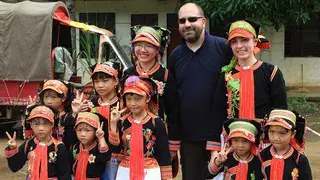 A GSM and children in traditional clothing, from teh Yao village
